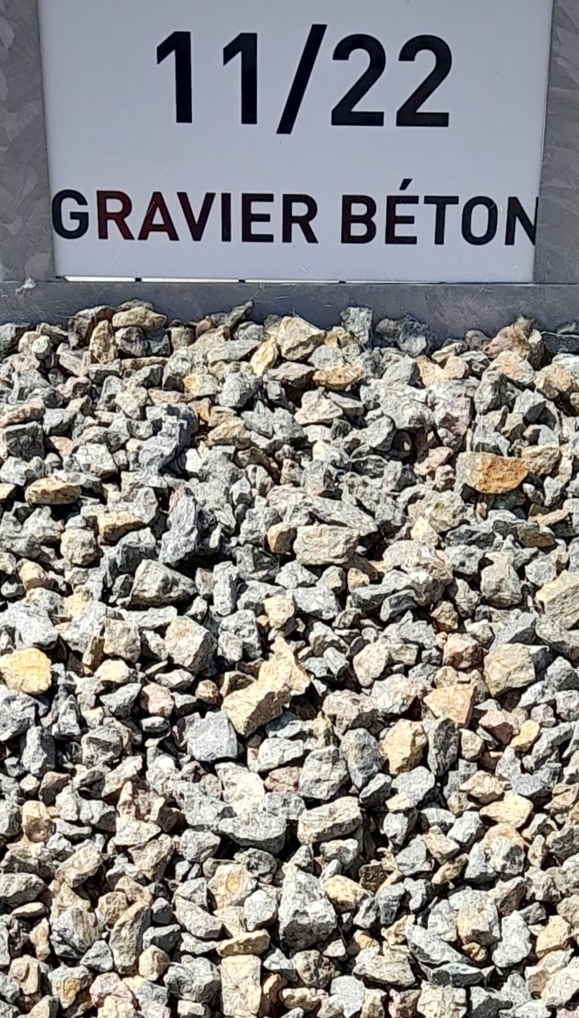 Tas de gravier béton de taille 11/22 mm, avec une pancarte blanche indiquant "11/22 GRAVIER BÉTON" en majuscules posée à l’arrière.