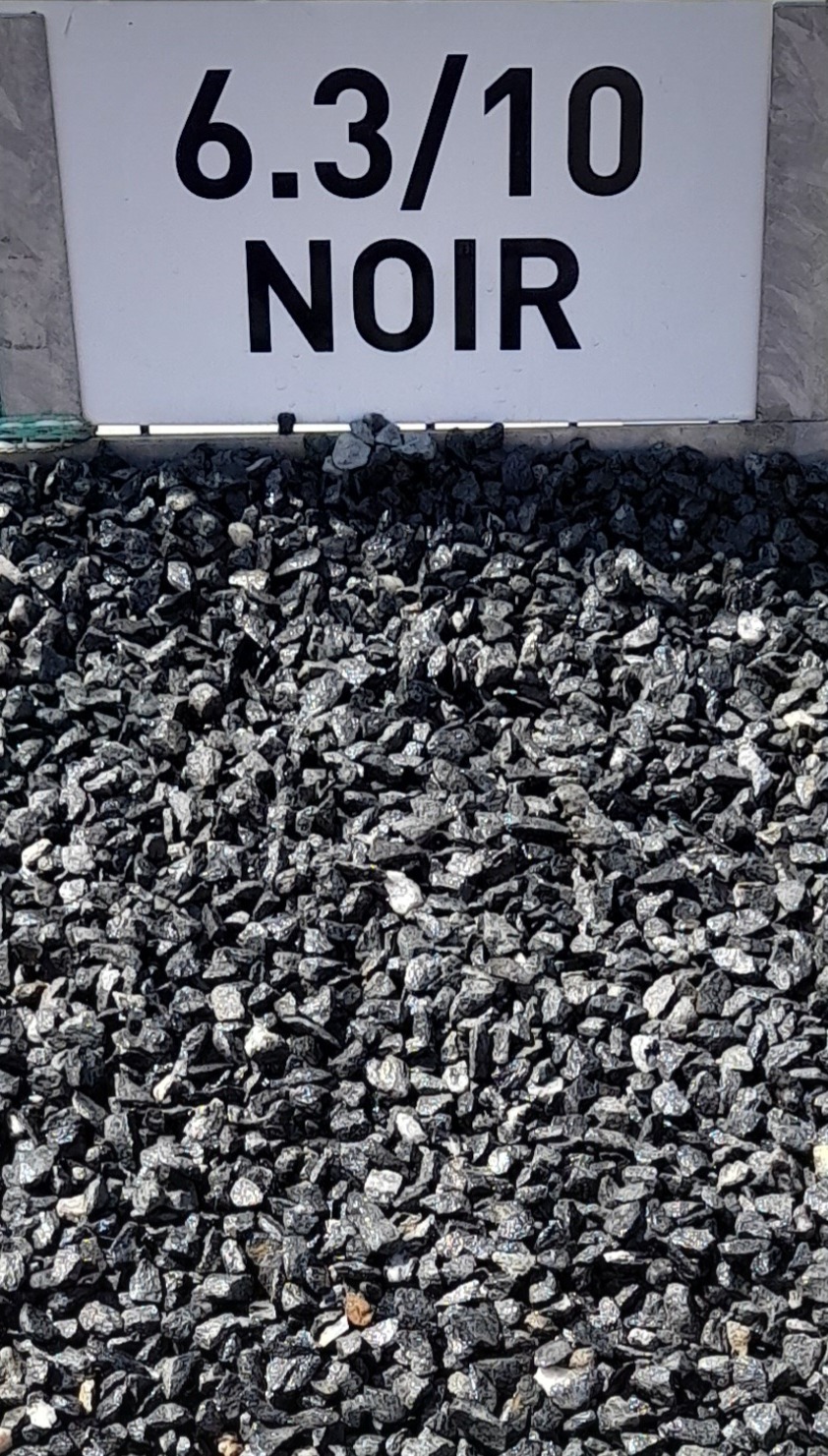 Tas de granulats noirs avec un panneau au-dessus indiquant "6.3/10 NOIR", représentant la taille et la couleur des matériaux.