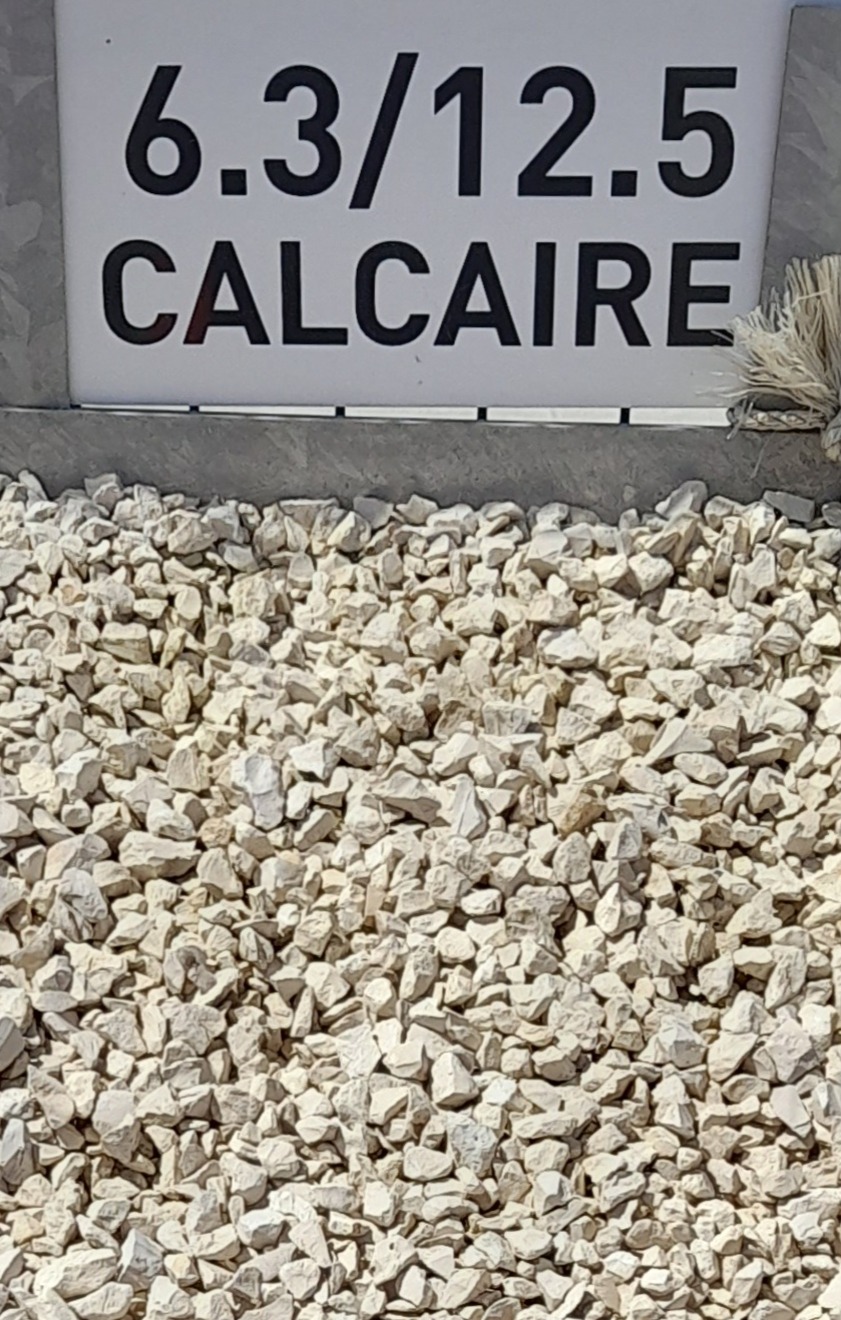 Graviers de calcaire blanc de taille 6.3/12.5 cm, avec un panneau indiquant "6.3/12.5 CALCAIRE" en arrière-plan.